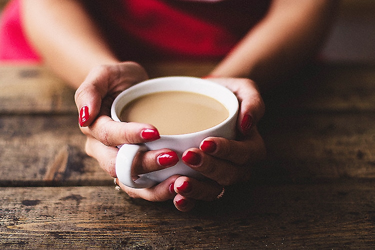 woman holding a warm cup of cacao